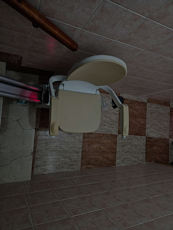 Silla salvaescaleras vista desde arriba en el inicio de una escalera estrecha