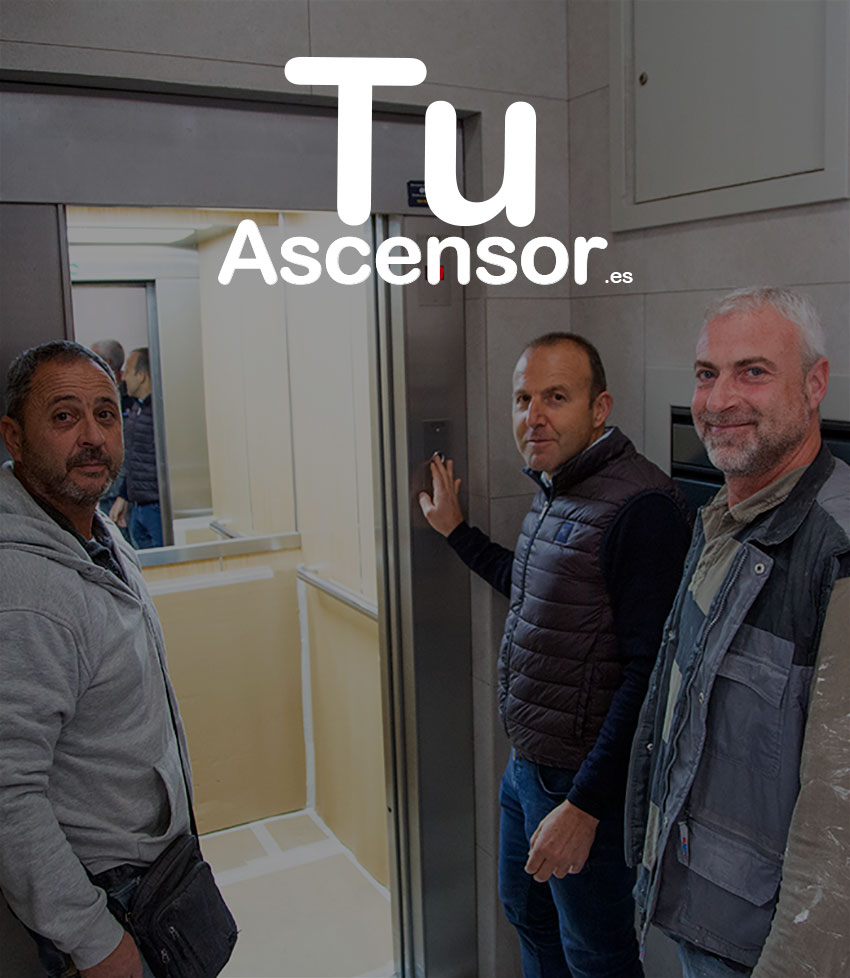 Tres hombres delante de la puerta abierta de un ascensor, mirando a la cámara.