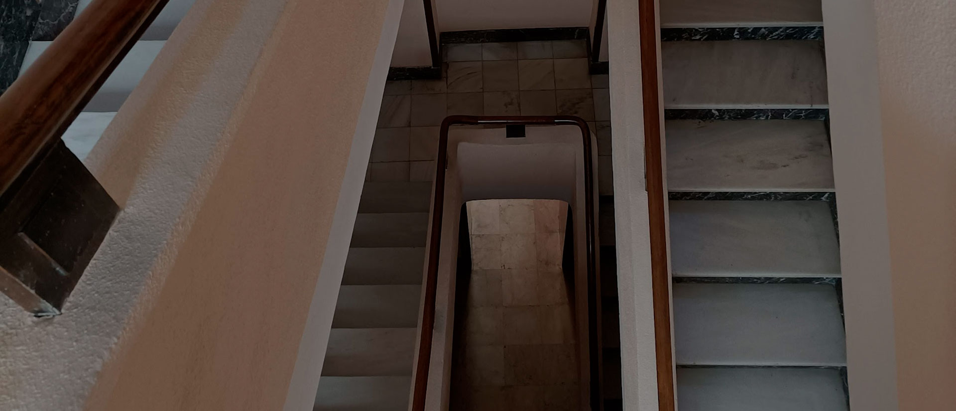 Vista de un hueco de escalera asomándose desde un rellano